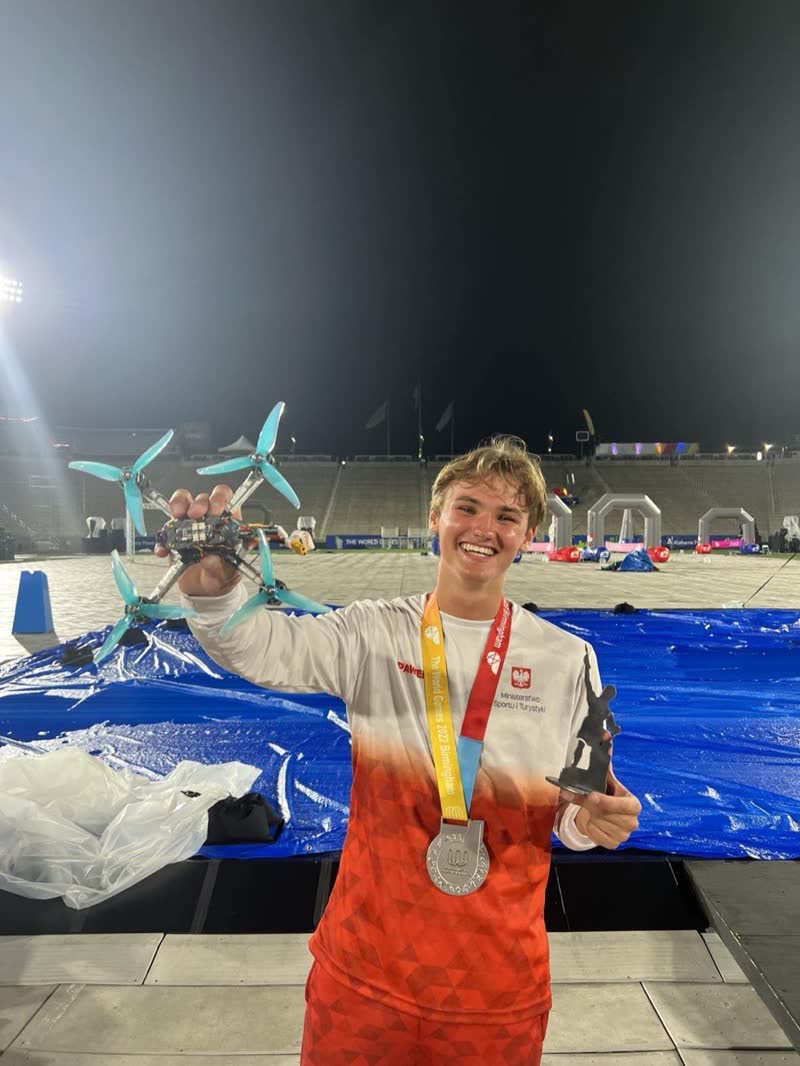 Paweł Laszczak ze swoim dronem wyścigowym i srebrnym medalem The World Games 2022 w Birmingham.